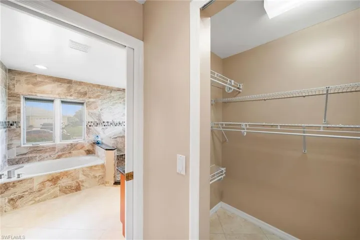 Walk in closet with light tile patterned floors