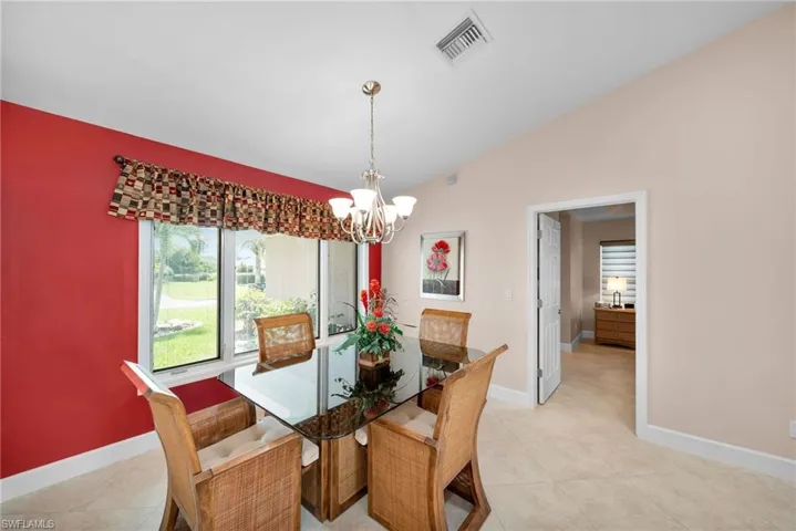 Tiled dining room with an inviting chandelier and lofted ceiling