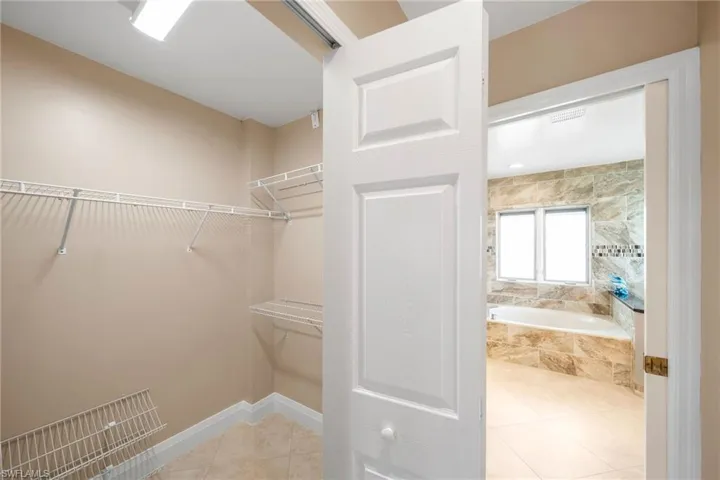 Spacious closet with light tile patterned floors