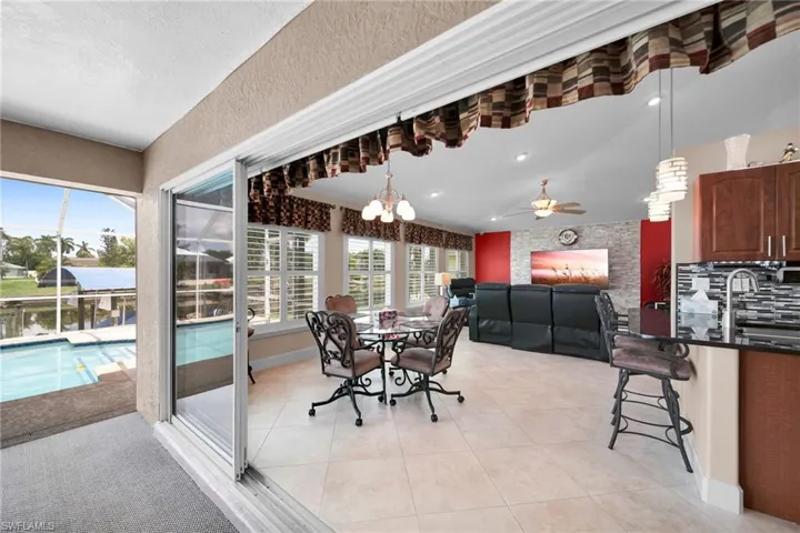 Dining space featuring ceiling fan with notable chandelier and light tile patterned floors
