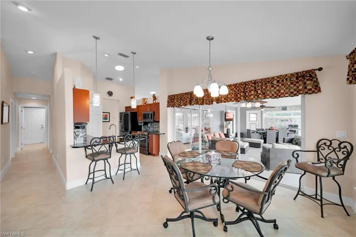 Dining room featuring light tile patterned flooring and ceiling fan with notable chandelier