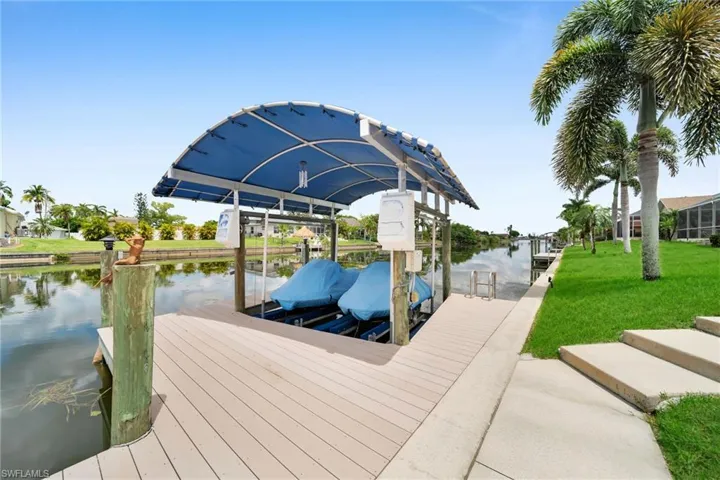 View of dock featuring a yard and a water view