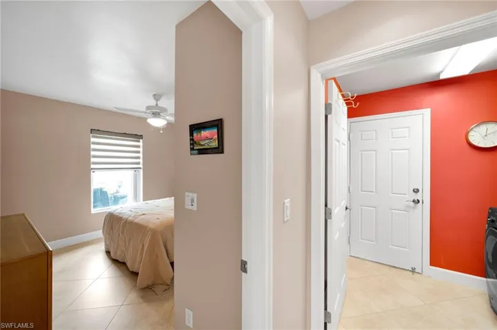 Hallway with washer / clothes dryer and light tile patterned floors