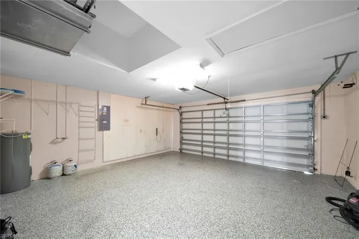 Garage featuring electric water heater and electric panel