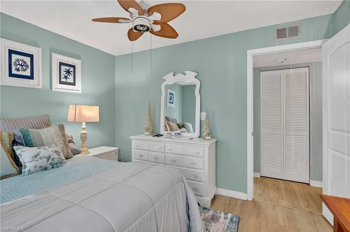 Bedroom with light wood-type flooring, a textured ceiling, and a ceiling fan