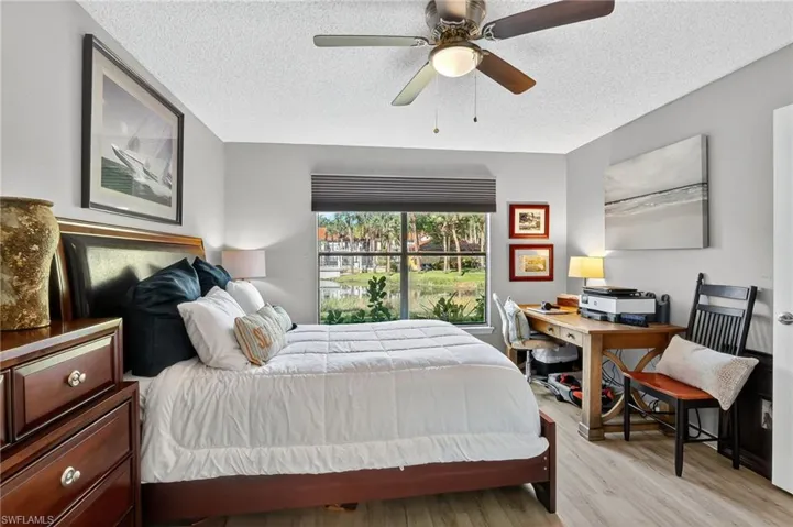 Bedroom featuring wood finished floors, a textured ceiling, and a ceiling fan