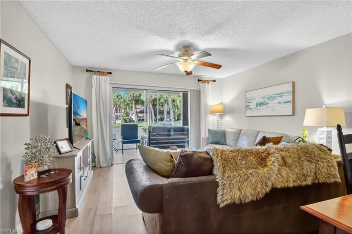 Living area with wood finished floors, a textured ceiling, and ceiling fan