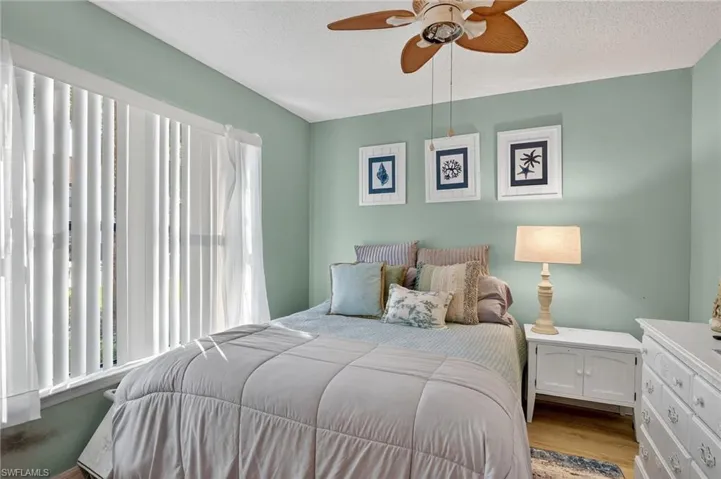 Bedroom with a textured ceiling, wood finished floors, and ceiling fan
