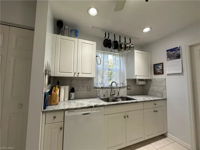 Kitchen with dishwashing machine, sink, white shaker cabinetry, tasteful backsplash, and granite countertops