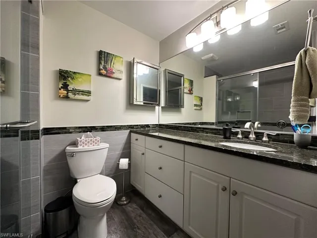 Master Bathroom with tile walls, hardwood / wood-style flooring, and vanity