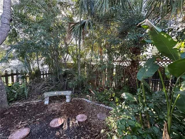 View of landscape area with sitting bench