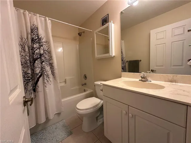 Full Guest bathroom featuring vanity, toilet, tile patterned flooring, and shower / bath combo