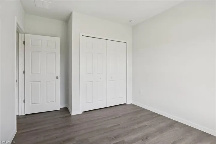 Unfurnished bedroom with a closet and wood-type flooring