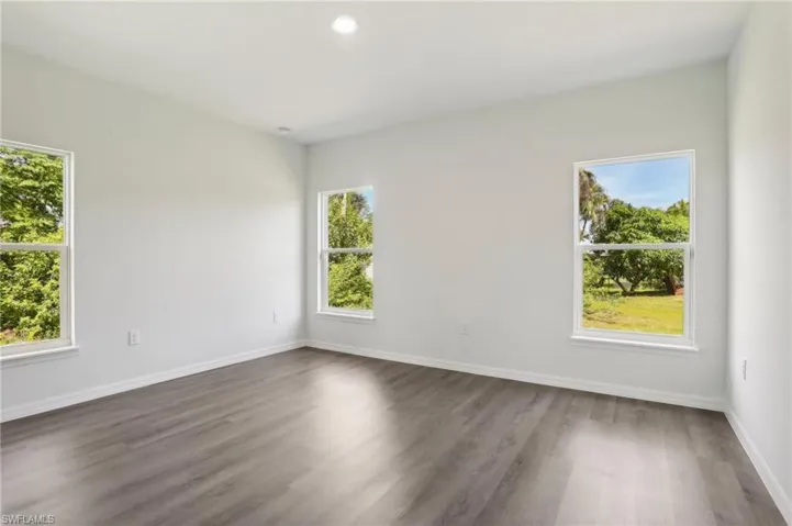 Spare room featuring a wealth of natural light and wood-type flooring