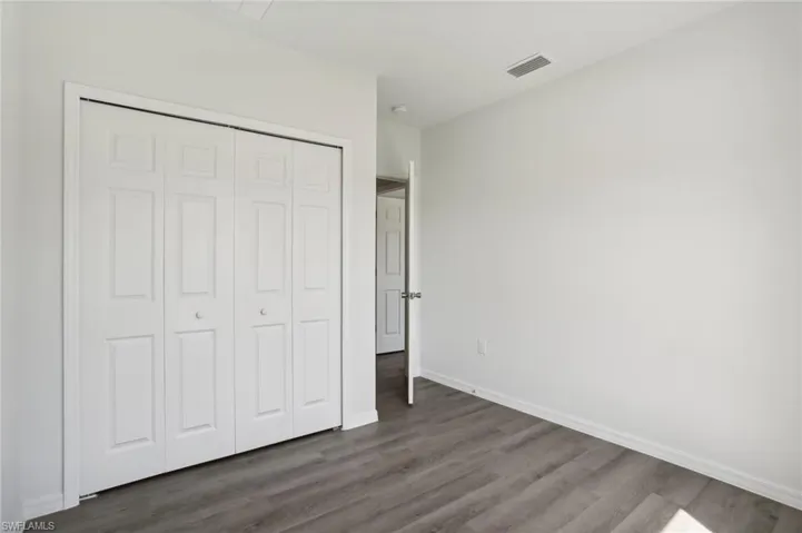 Unfurnished bedroom with a closet and dark hardwood / wood-style floors