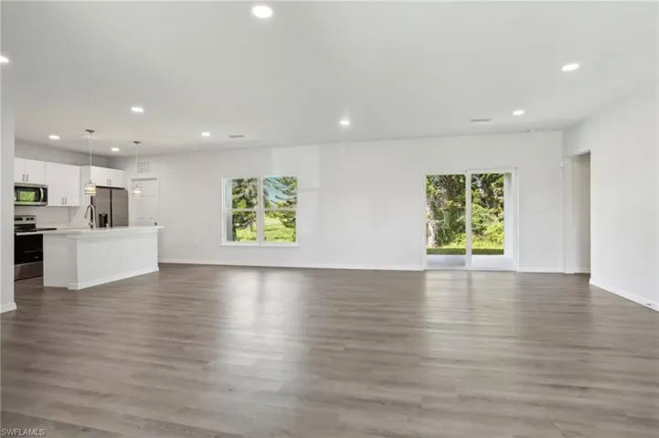 Unfurnished living room featuring sink and wood-type flooring