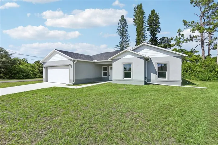 Single story home with a front yard and a garage