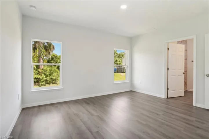 Unfurnished room featuring plenty of natural light and wood-type flooring