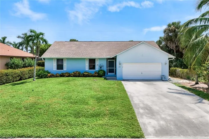 Single story home with a garage and a front lawn