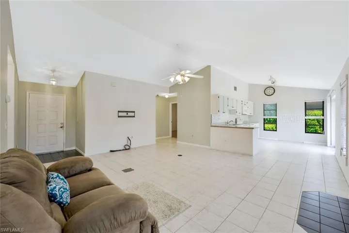 Tiled living room featuring vaulted ceiling and ceiling fan