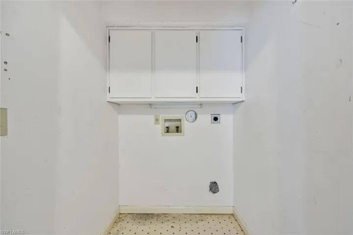 Clothes washing area with cabinets, washer hookup, and hookup for an electric dryer