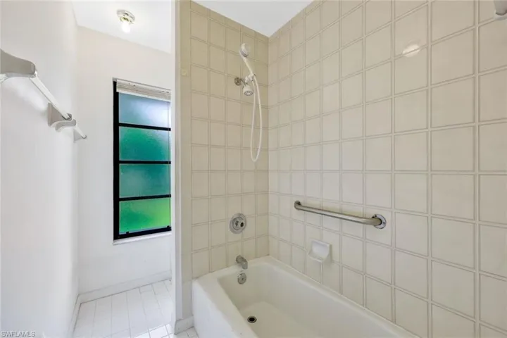 Bathroom with tile patterned flooring and tiled shower / bath combo