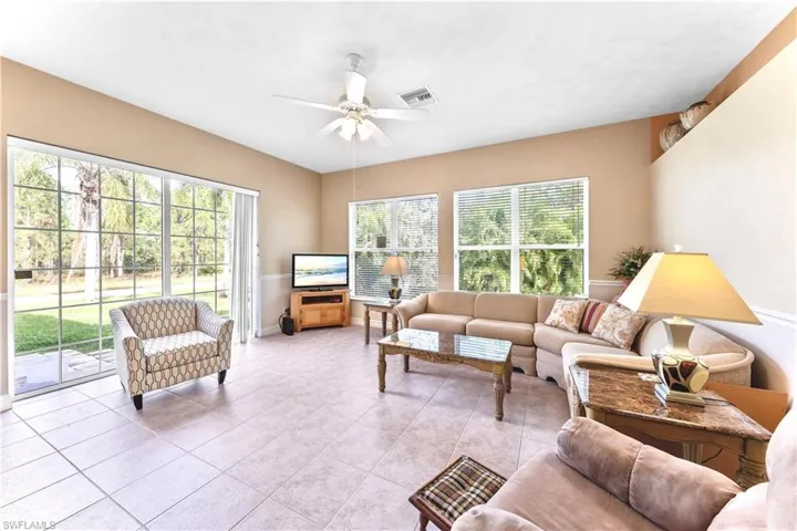 Tiled living room featuring ceiling fan and a healthy amount of sunlight
