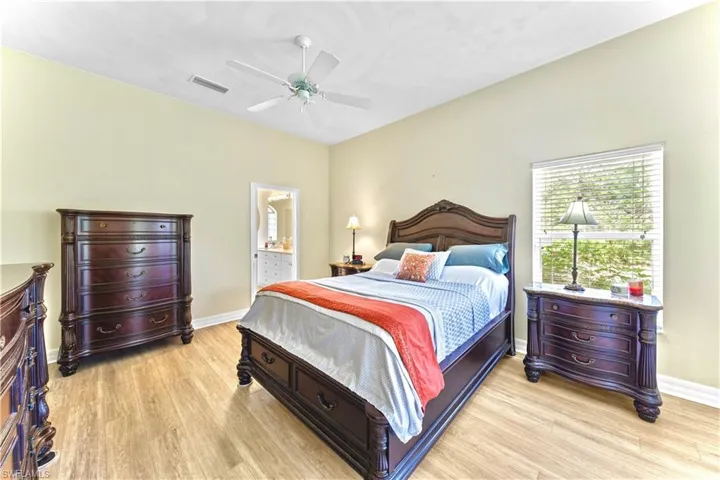 Bedroom featuring ensuite bath, ceiling fan, and light hardwood / wood-style flooring