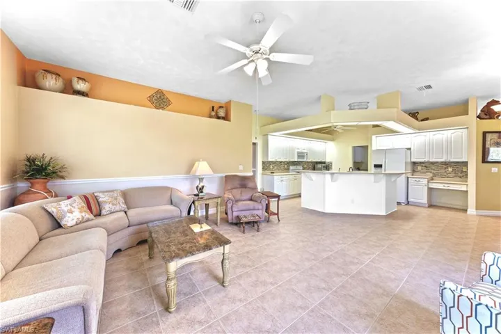 Living room with ceiling fan and light tile patterned floors