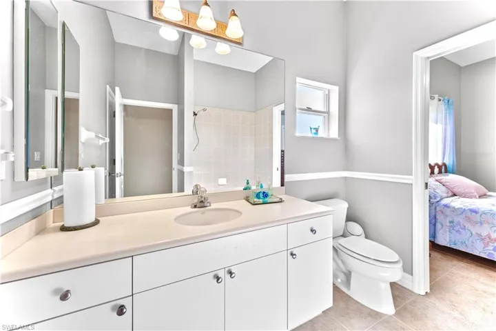 Bathroom featuring tile patterned flooring, vanity, and toilet