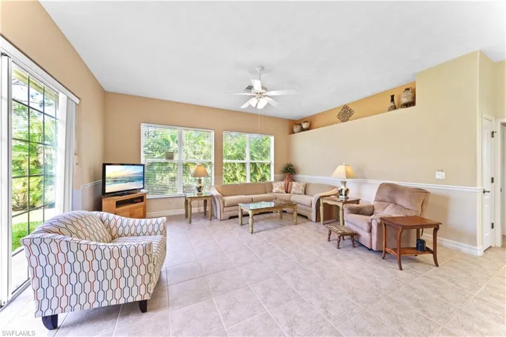Tiled living room featuring a wealth of natural light and ceiling fan