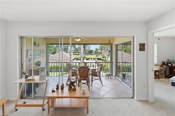 The living room opens wide to the glassed lanai and the courtyard beyond