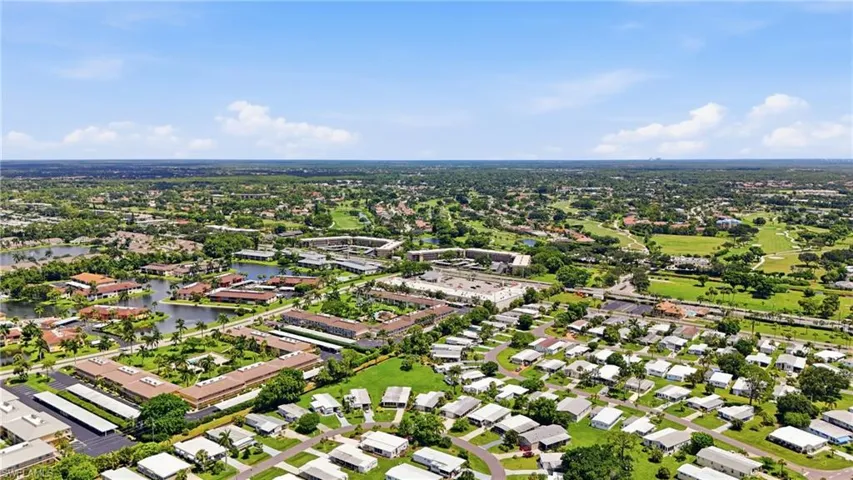 Aerial perspective showcasing residential developments, lush green spaces, and a prominent golf course