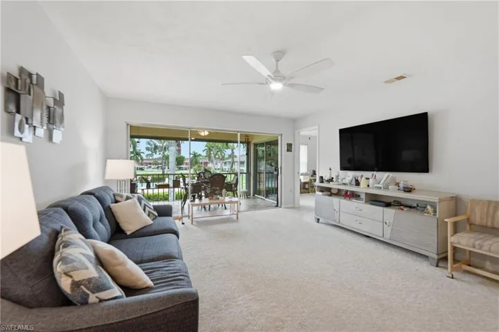 Bright living space with light-toned carpeting and a ceiling fan