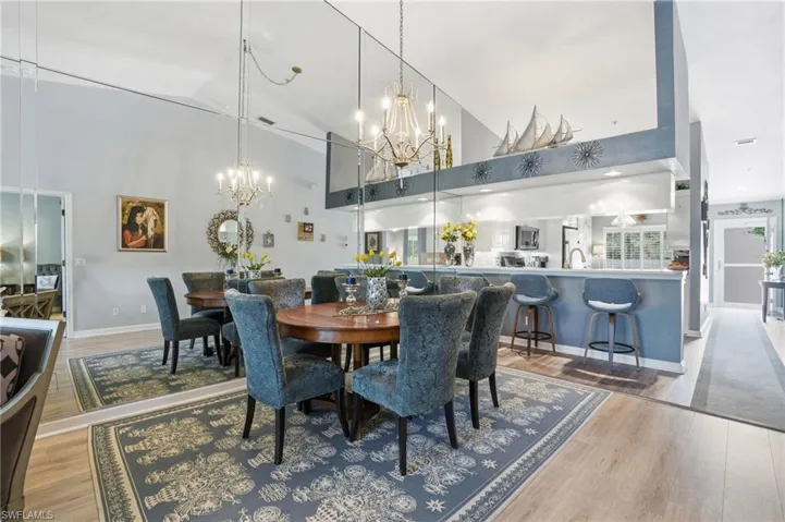 Dining space featuring a chandelier, light wood-style flooring, and lofted ceiling