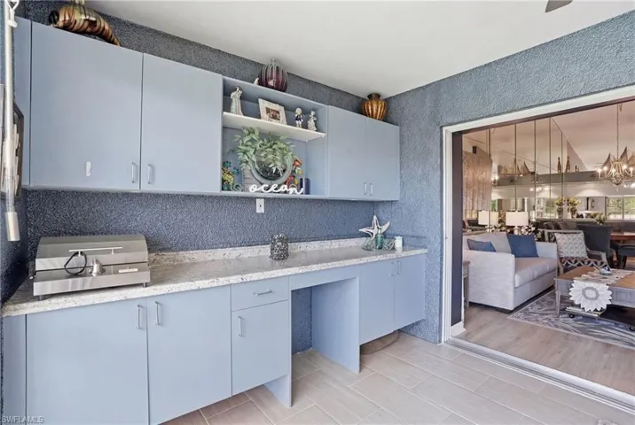 Kitchen featuring open shelves, suspended lighting, gray cabinets, and open floor plan