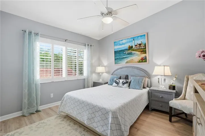 Bedroom with lofted ceiling, light wood-style floors, and a ceiling fan