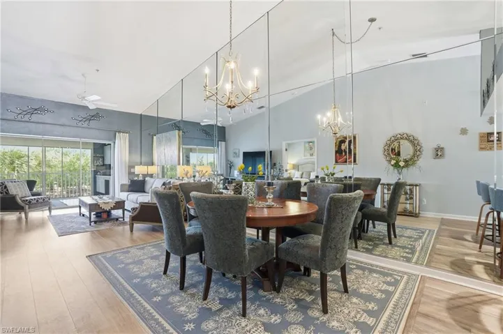 Dining area with light wood-type flooring, suspended lighting, vaulted ceiling, healthy amount of natural light, and ceiling fan