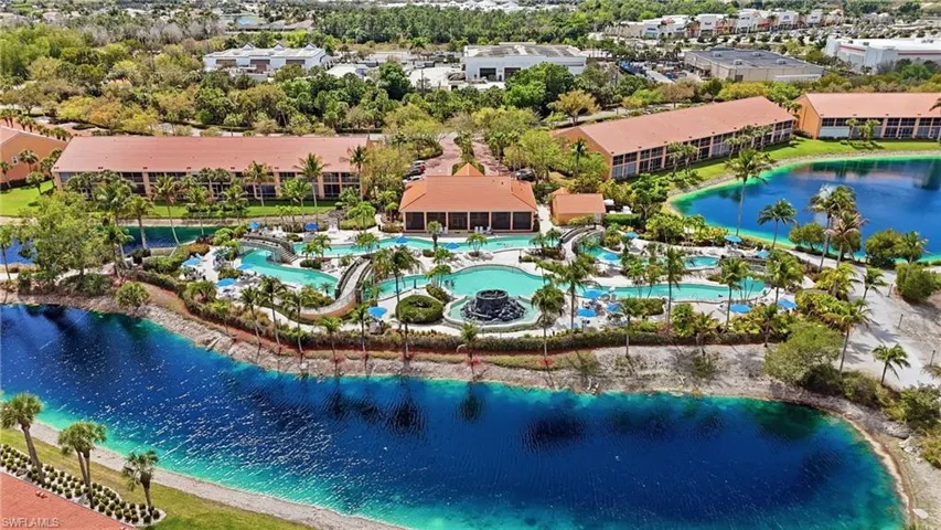 Drone / aerial view of a nearby body of water and a pool area