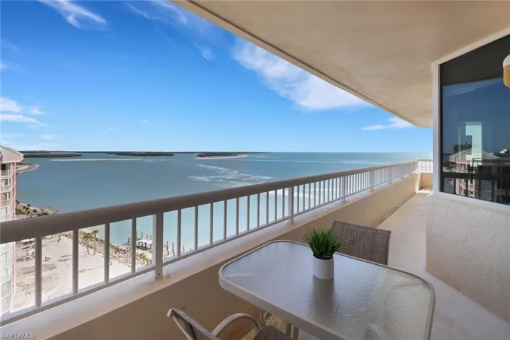 Balcony featuring view of water and beach