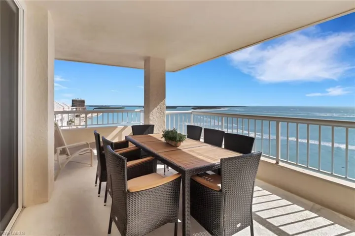 Balcony with outdoor dining space and a water view