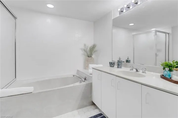 Bathroom featuring vanity, a bath, recessed lighting, and a shower stall