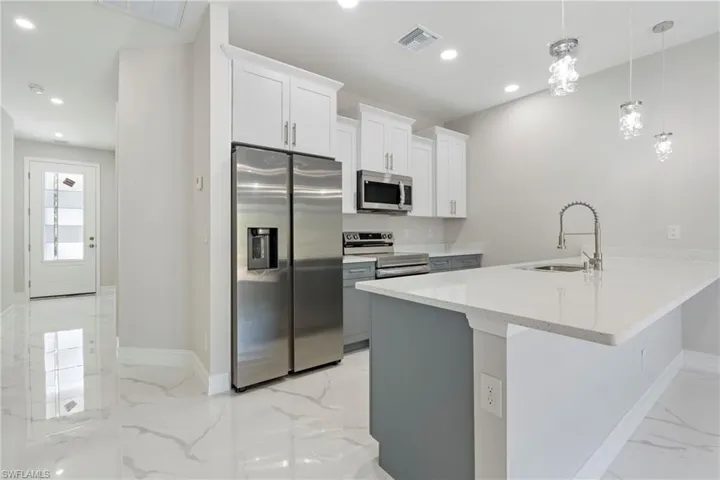 Kitchen featuring marble finish floor, recessed lighting, visible vents, appliances with stainless steel finishes, and a sink