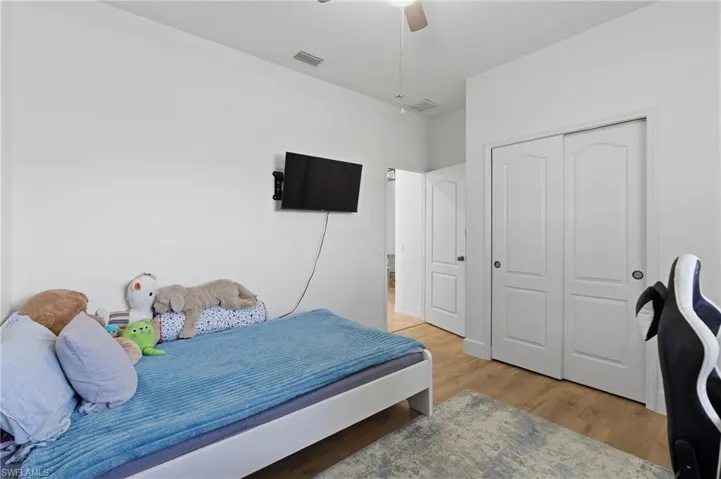 Bedroom featuring light wood finished floors, a closet, and a ceiling fan
