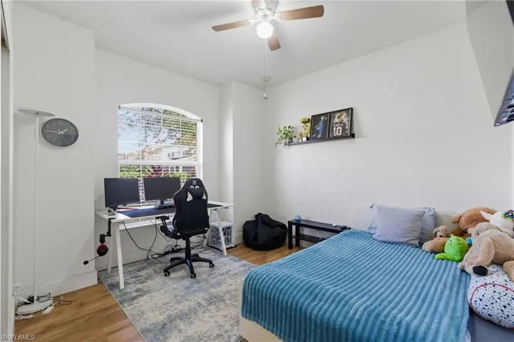 Bedroom with a desk, wood finished floors, and ceiling fan