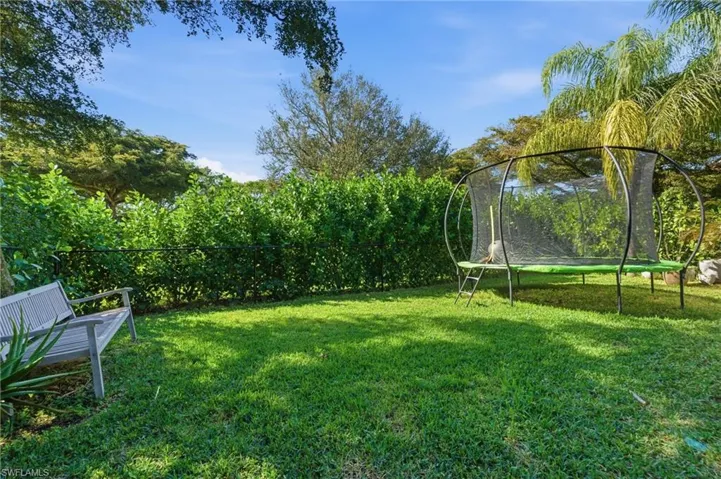 Fenced backyard with a trampoline