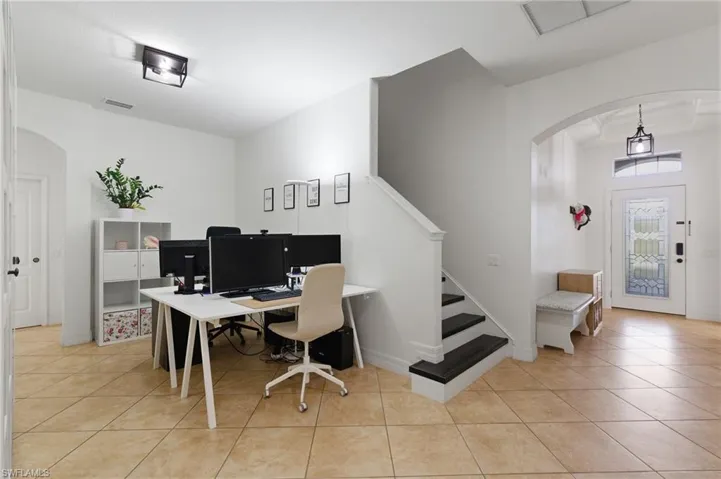 Home office with arched walkways and light tile patterned flooring