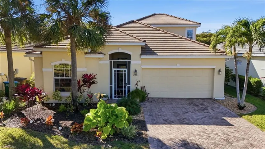 Mediterranean / spanish house featuring a garage, decorative driveway, stucco siding, and a tiled roof