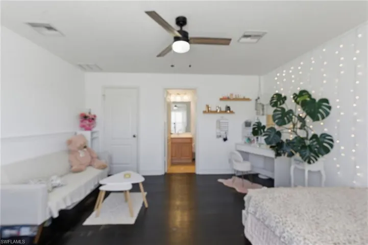Bedroom with dark wood-style flooring and ceiling fan