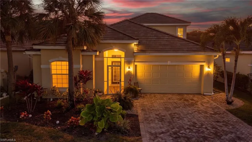 View of front of property featuring stucco siding, decorative driveway, and a garage